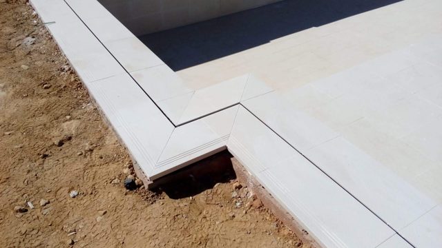 Piscina desbordante con cascada y revestimiento de porcelánico · San Roque