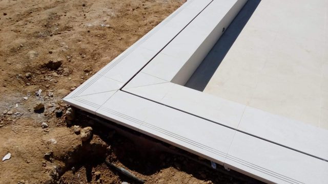 Piscina desbordante con cascada y revestimiento de porcelánico · San Roque