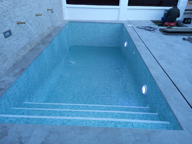 Piscina de 6 × 3 m con revestimiento de gresite y andén de gres porcelánico · Ubrique