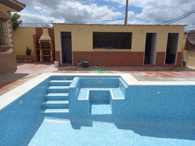 Piscina de 8 × 4 m con revestimiento de gresite, entrada lateral y formación de jacuzzi · Arcos de la Frontera