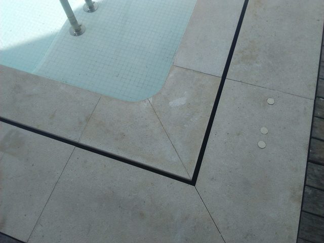 Ejemplo de rejilla oculta en coronación de piscina