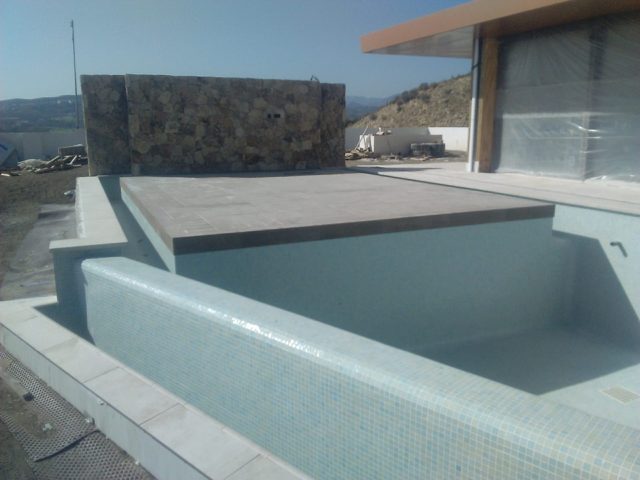 Piscina infinity con isla y revestimiento de gresite · La Cala de Mijas