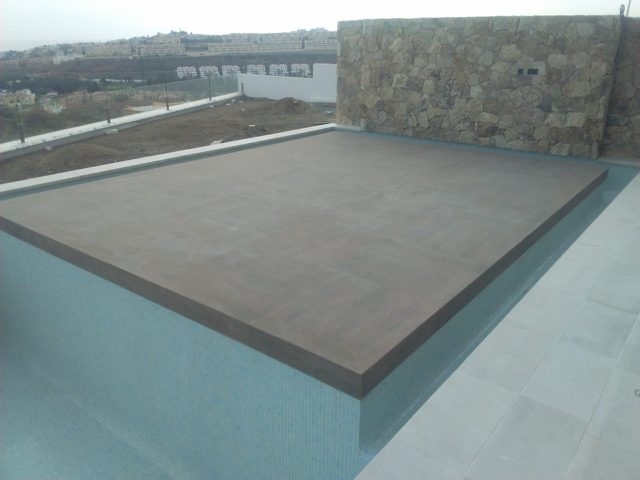 Piscina infinity con isla y revestimiento de gresite · La Cala de Mijas