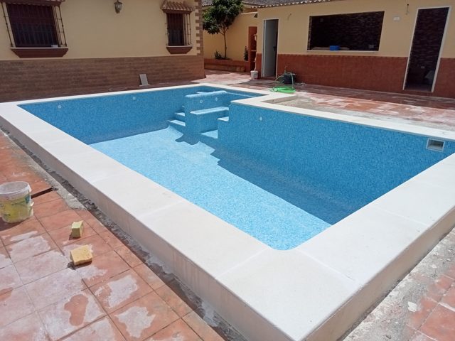 Piscina de 8 × 4 m con revestimiento de gresite, entrada lateral y formación de jacuzzi · Arcos de la Frontera