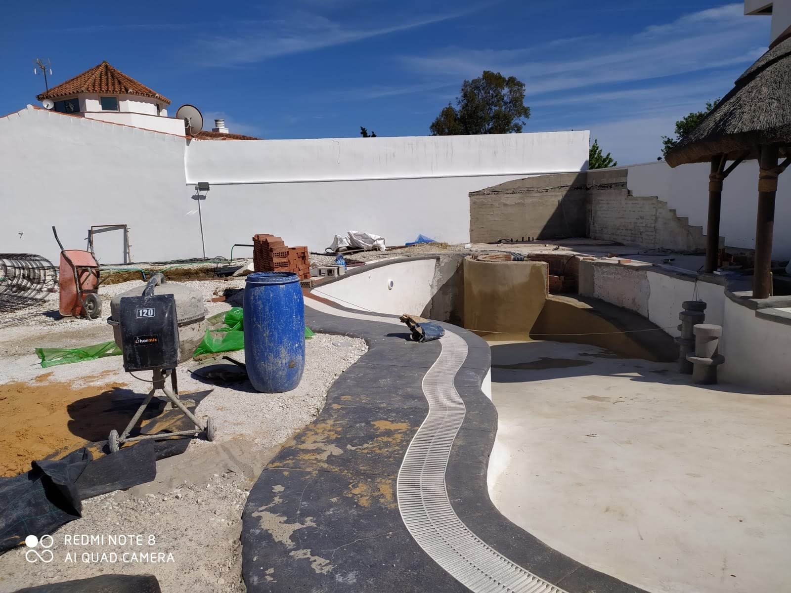 Rejilla desbordante en el borde curvo de la piscina de Santa Margarita durante la reforma