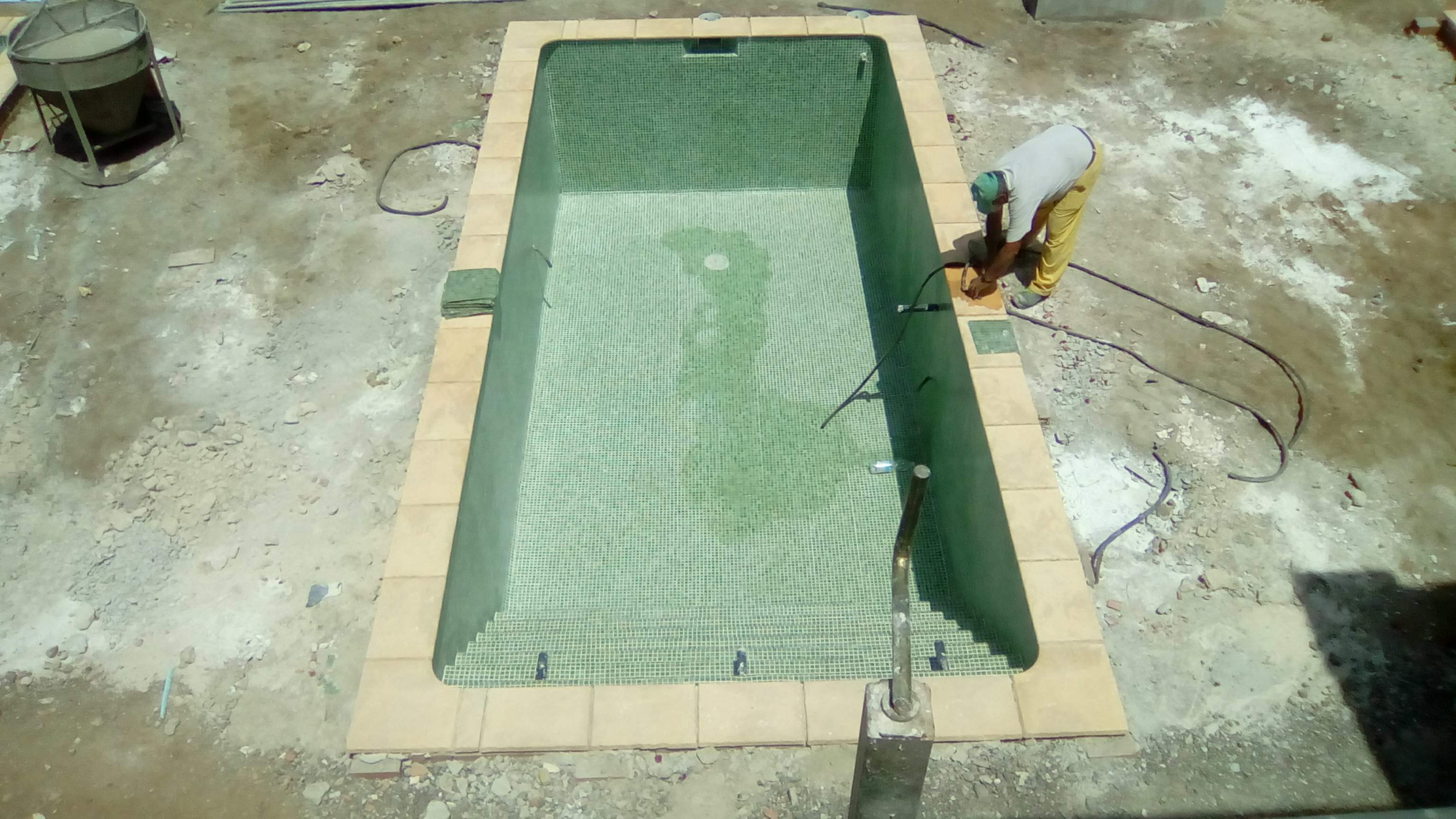 Revestimiento de tono verde en un vaso vacío; exterior en obra.