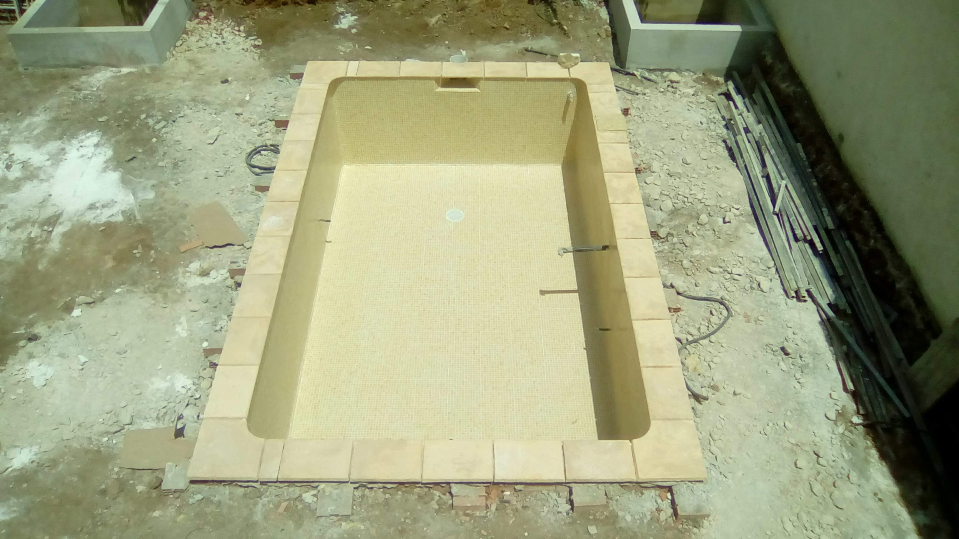 Revestimiento de tono beige en un vaso vacío; exterior en obra.
