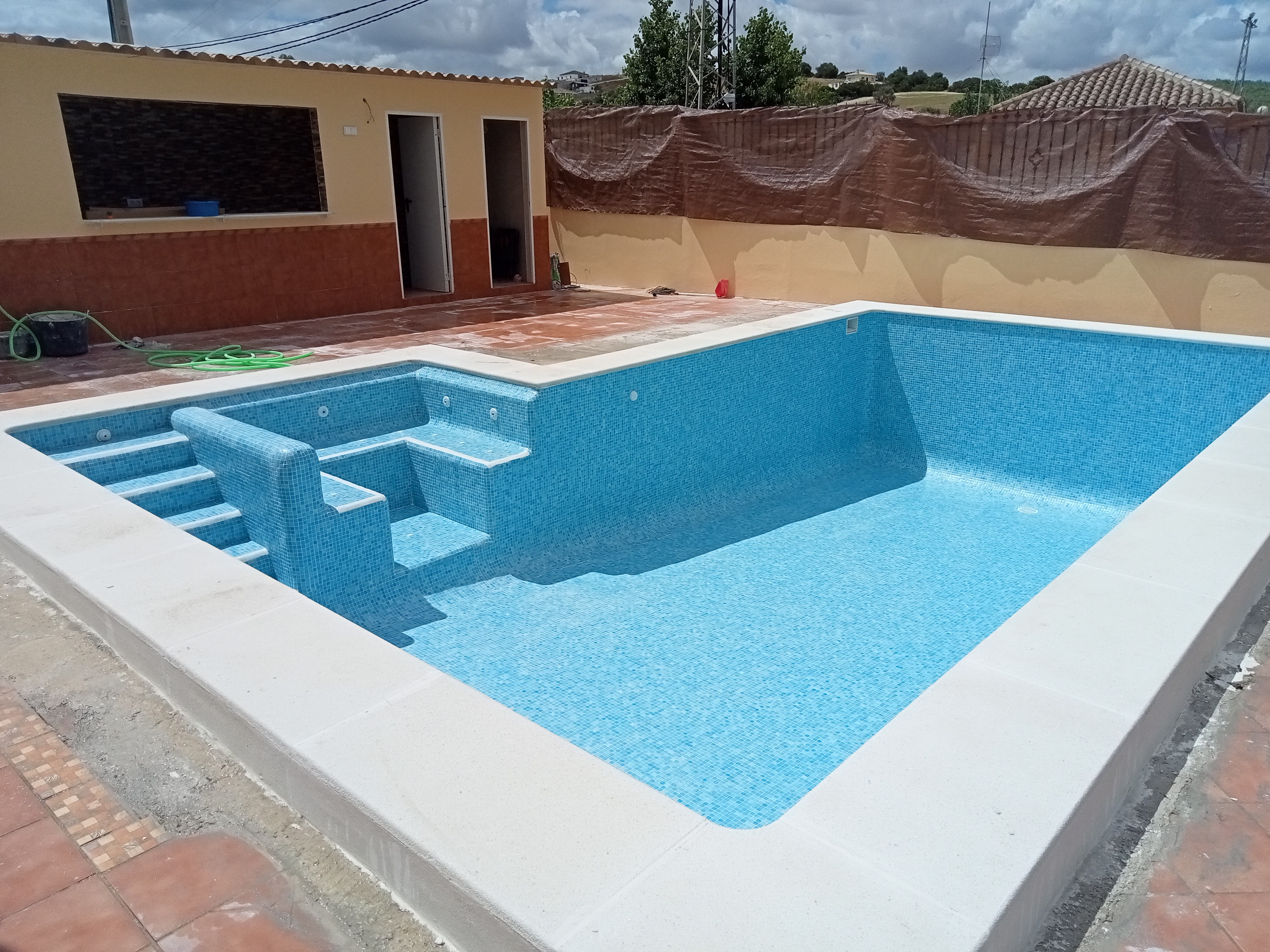 Vista general del vaso revestido en gresite azul; exterior en obra.